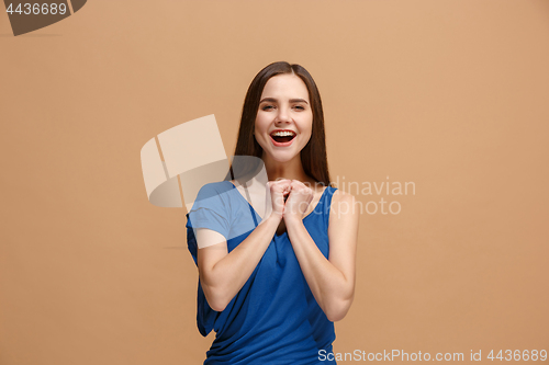 Image of The happy business woman standing and smiling against pastel background.