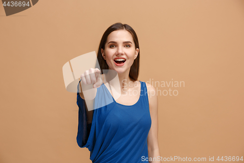 Image of The happy woman point you and want you, half length closeup portrait on pastel background.