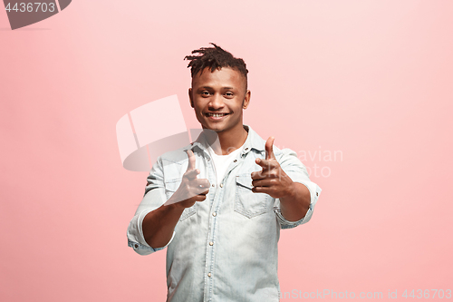 Image of The happy business man standing and smiling against pink background.