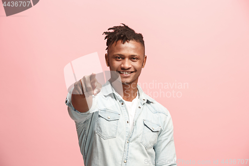 Image of The happy businessman point you and want you, half length closeup portrait on pink background.