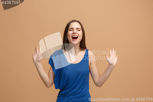 Image of The happy business woman standing and smiling against pastel background.