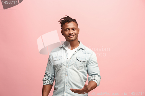 Image of The happy business man standing and smiling against pink background.