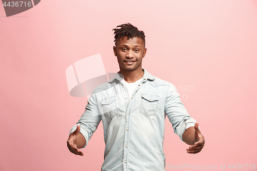 Image of The happy business man standing and smiling against pink background.