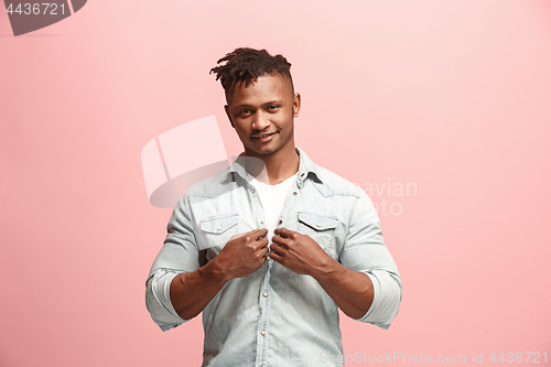 Image of The happy business man standing and smiling against pink background.