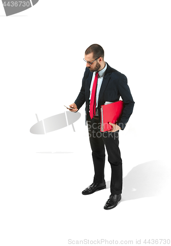 Image of Serious businessman wiht mobile phone with folder in hand isolated over white background in studio