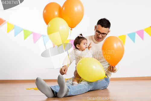 Image of father and daughter with birthday party balloons