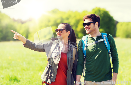 Image of happy couple with backpacks hiking outdoors