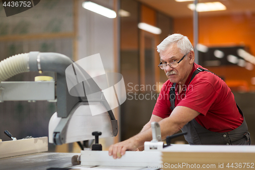 Image of carpenter with panel saw and fibreboard at factory