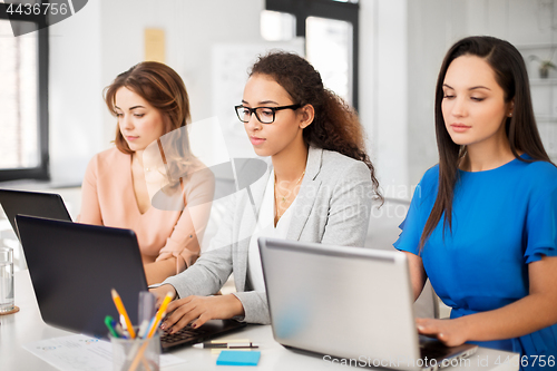 Image of businesswomen with laptop working at office