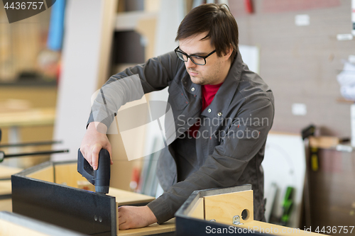 Image of assembler with screwdriver making furniture