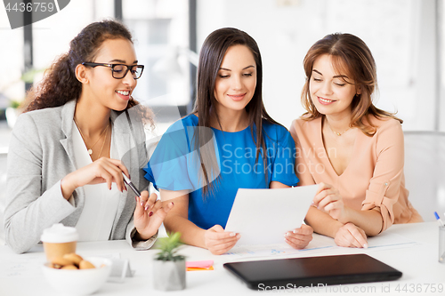 Image of businesswomen discussing papers at office