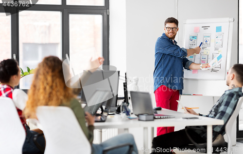 Image of creative man showing user interface at office