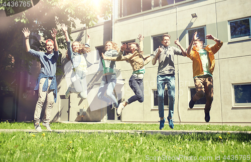 Image of happy teenage students or friends jumping outdoors