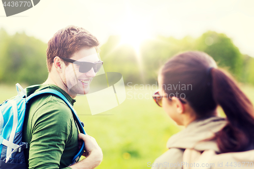 Image of smiling couple with backpacks in nature