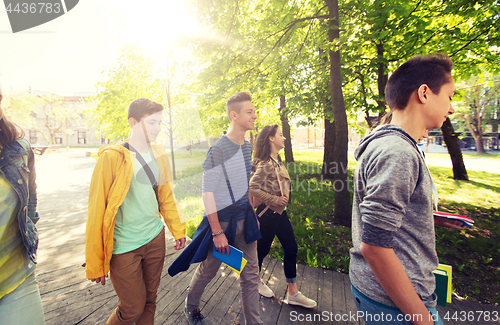 Image of group of happy teenage students walking outdoors