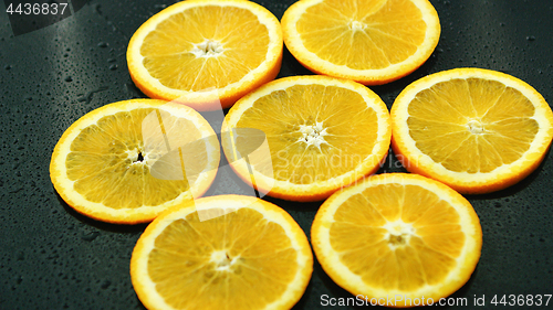 Image of Orange slices on dark desk 