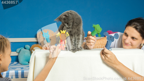 Image of Mom and daughter play a puppet theater with a tired cat