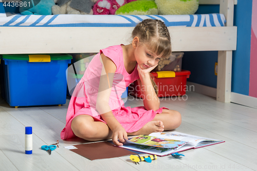 Image of The girl with interest leafs through the book of creativity