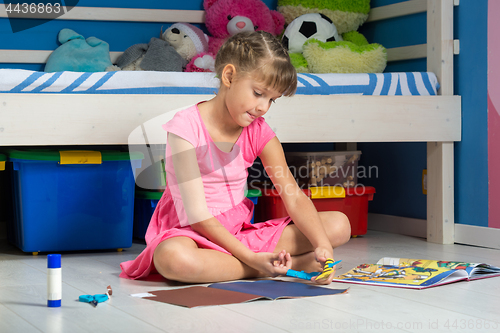 Image of Girl is making out of colored paper figurines