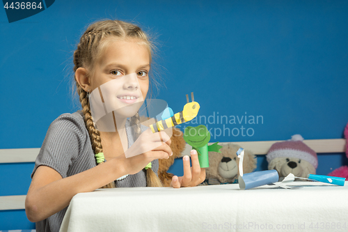 Image of Merry girl plays in a makeshift finger puppet show