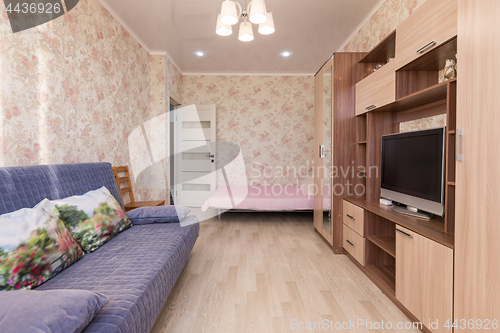 Image of Interior of the hotel room, bed, sofa, wardrobes, TV