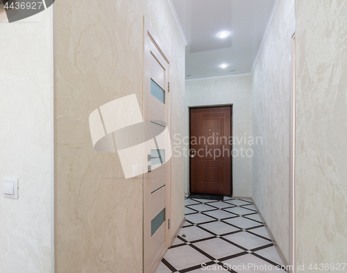 Image of Long corridor in the apartment, closed door to the bathroom