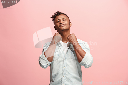 Image of The happy business man standing and smiling against pink background.