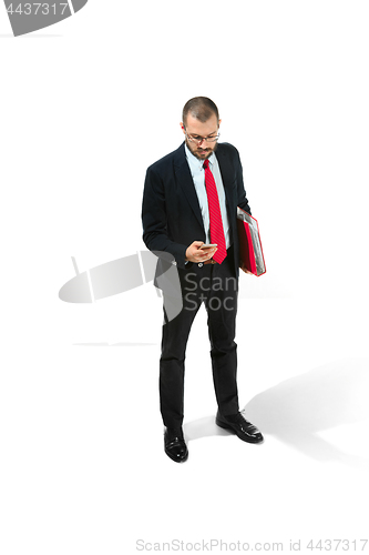 Image of Serious businessman wiht mobile phone with folder in hand isolated over white background in studio