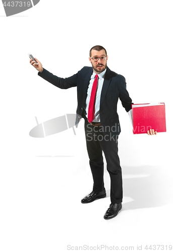 Image of Angry businessman talking on the phone with folder in hand isolated over white background in studio shooting