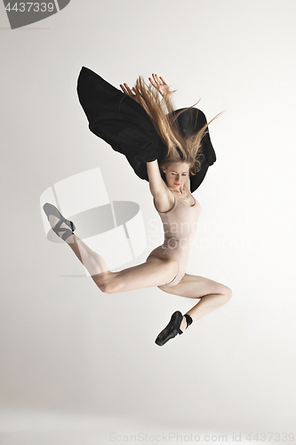 Image of Young beautiful dancer in beige swimsuit dancing on gray background