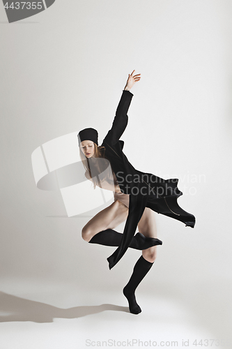 Image of Young beautiful dancer in beige swimsuit dancing on gray background