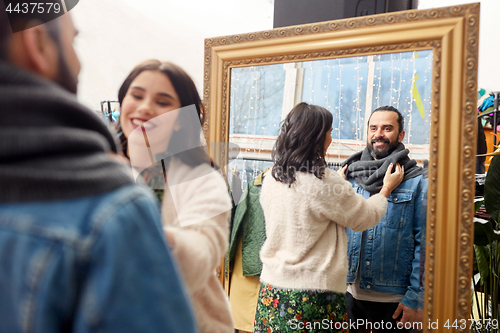 Image of couple choosing clothes at vintage clothing store