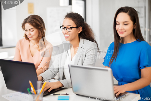 Image of businesswomen with laptop working at office
