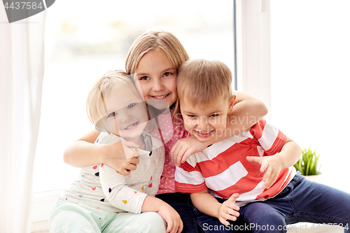 Image of happy little kids hugging at window