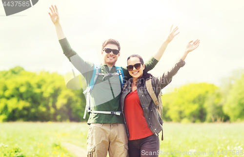 Image of happy couple with backpacks hiking outdoors