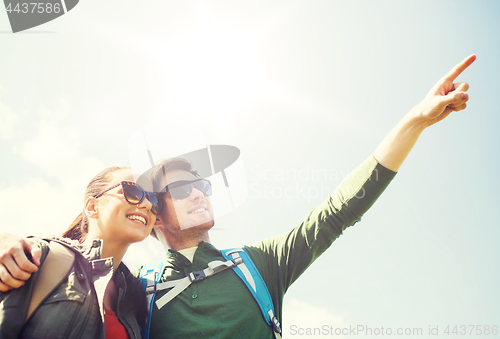 Image of happy couple with backpacks hiking outdoors