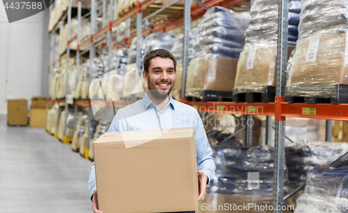 Image of happy man with cardboard parcel box at warehouse