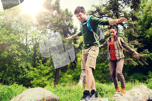 Image of happy couple with backpacks hiking outdoors