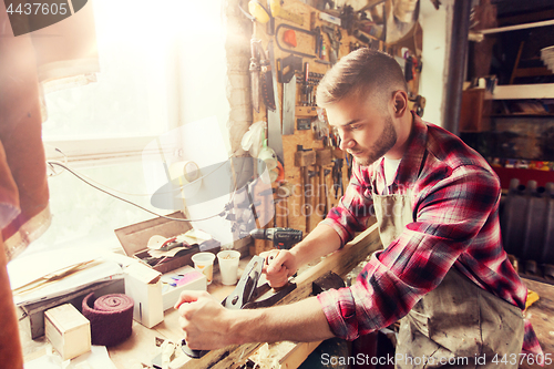 Image of carpenter working with plane and wood at workshop