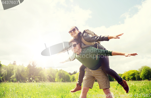 Image of happy couple with backpacks having fun outdoors