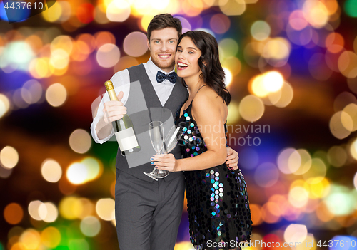 Image of happy couple with champagne and glasses at party