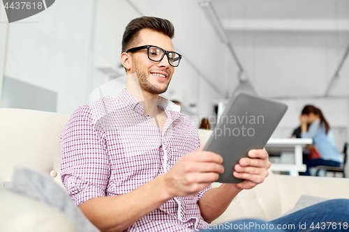 Image of man in glasses with tablet pc working at office