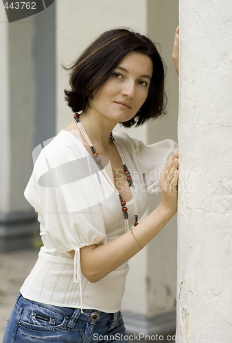 Image of pretty woman standing near white column