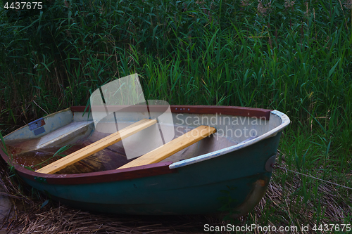 Image of Old Metal Rowing Boat On The Background Of Reeds