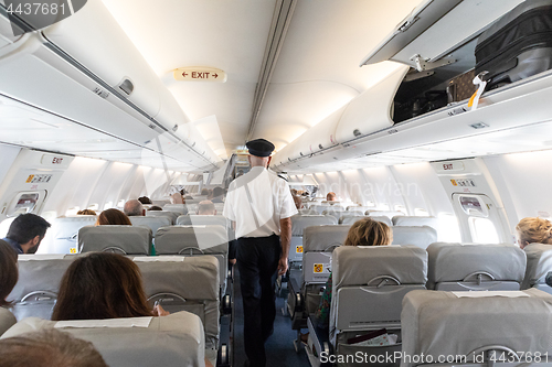 Image of Interior of commercial airplane with passengers on their seats during flight.