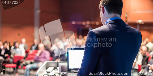 Image of Public speaker giving talk at business event.