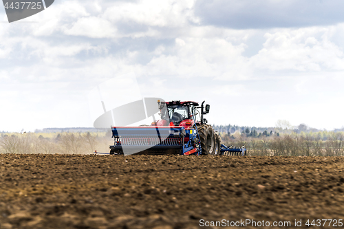 Image of Red tractor driving on a field