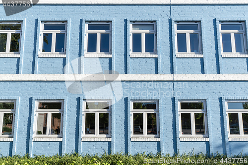 Image of Blue brick house with white windows