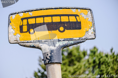 Image of Yellow bus stop sign with a rough look