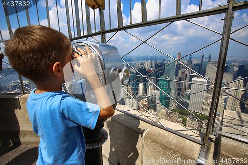 Image of Little boy using binoculars and watched on the New York Skyline 